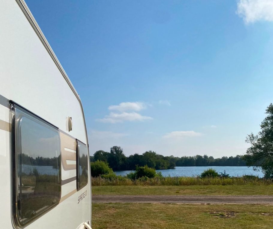 Caravan Rental by the Lake SquaredAway rental caravan pitched beside a lake at a campsite.